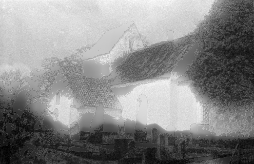 A grainy, fog-shrouded photograph of a ruined ivy-covered stone church with weathered gravestones in the mist